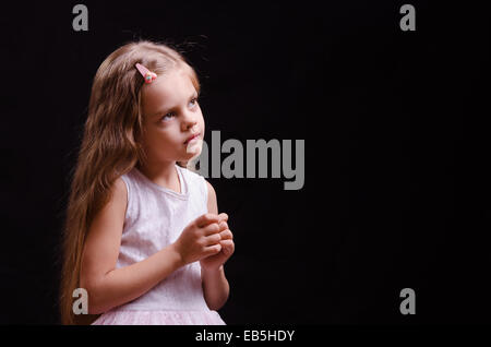 Portrait d'une belle petite fille de cinq ans sur un fond noir Banque D'Images