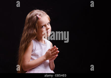 Portrait d'une belle petite fille de cinq ans sur un fond noir Banque D'Images