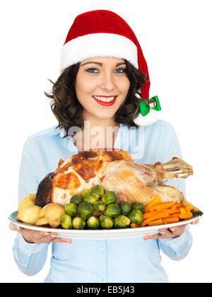 Jeune femme en rouge Santa Hat Holding Rôti de dindon et de légumes prêts à manger pour le déjeuner de Noël isolé sur fond blanc Banque D'Images