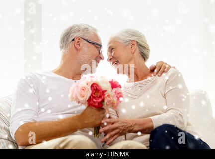 Happy senior couple avec bouquet de fleurs à la maison Banque D'Images