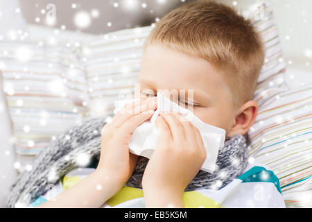 Mauvais Garçon blowing nose avec les tissus à la maison Banque D'Images