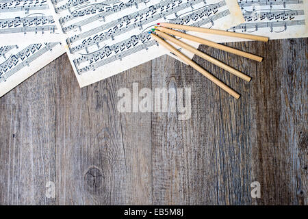 Partitions musicales avec des crayons sur une table Banque D'Images