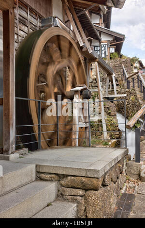 La ville touristique populaire de Magome, au Japon, sur l'ancienne autoroute de la période Edo Nakasendo. Ancienne roue d'eau en bois tournant à l'extérieur d'une maison de miller. Banque D'Images