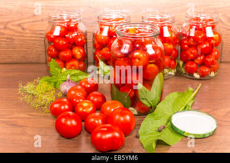 Tomates en conserve dans des bocaux en verre avec des épices Banque D'Images