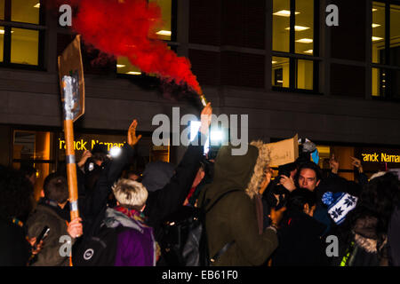 Londres, le 26 novembre 2014. Un vigile pour adolescent Mike Brown qui a été abattu par un policier à Ferguson, New York cette année, a lieu en dehors de l'ambassade des États-Unis à Londres. L'anti-racisme et défenseurs de droits de l'homme appelé le 'urgence' protester à la suite d'un jugement du tribunal qui efface Policier Darren Wilson de meurtre. Sur la photo : le racisme anti-police-marcheurs se bombe de fumée dans le quartier exclusif de Mayfair de Londres. Banque D'Images