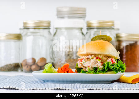 Sandwich à la salade de thon avec de la laitue sur une maison saine pain avec des bâtonnets de carotte et de céleri et un cornichon Banque D'Images