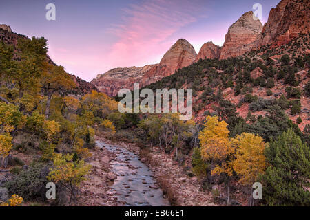 Le soleil qui donne de la couleur au ciel au-dessus de l'Utah Zion National Park à l'automne. Banque D'Images