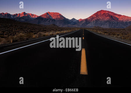 Une route menant à la montagne attire les personnes comme alpenglow est sur les sommets à l'aube. Banque D'Images