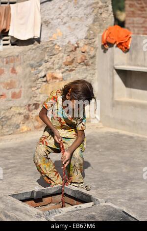 Levage d'une jeune Indienne pot d'eau à partir d'un réservoir d'eau de pluie l'Inde Banque D'Images
