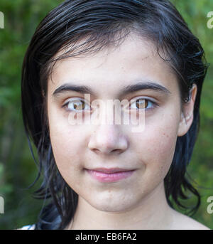 Close-up portrait d'une jeune fille aux cheveux noirs, à l'extérieur. Banque D'Images