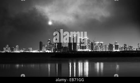 Photo en noir et blanc. Nuit sur la ville moderne avec la lune brillante. Manama, la capitale de Bahreïn, au Moyen-Orient Banque D'Images