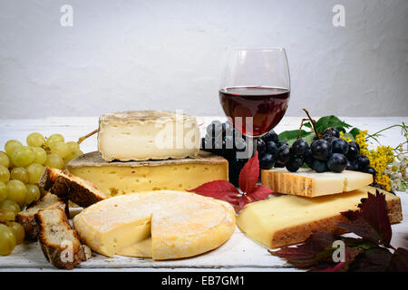 Les différents fromages de Savoie avec un verre de vin rouge Banque D'Images