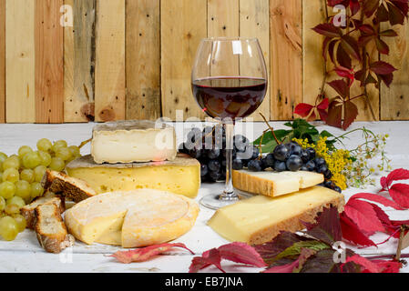 Les différents fromages de Savoie avec un verre de vin rouge Banque D'Images