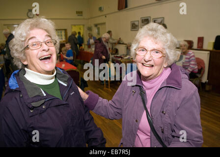 Smiley deux dames âgées dans un marché couvert de noël, hindhead, Hampshire, Royaume-Uni. Banque D'Images