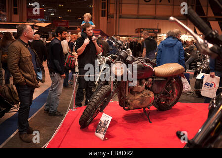 Les visiteurs de la Live show moto à Birmingham, NEC, jeter un oeil à une moto Triumph. Banque D'Images