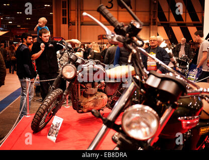 Les visiteurs de la Live show moto à Birmingham, NEC, jeter un oeil à une moto Triumph. Banque D'Images