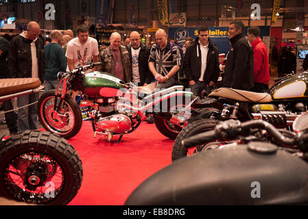 Les visiteurs de la Live show moto à Birmingham, NEC, jeter un oeil à une moto custom Triumph. Banque D'Images