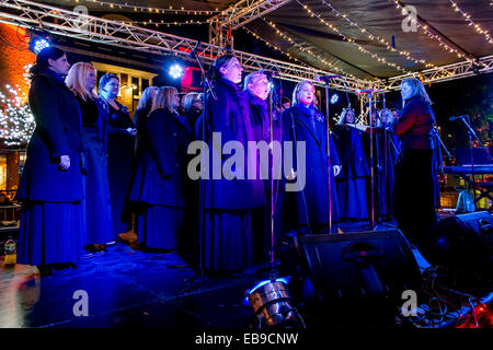 27 Salisbury Salisbury Novembre 2014 Ouverture du marché de noël nuit foules recueillies en dépit du mauvais temps Chalets vendre les marchandises de Noël et de divertissement par chorales locales . Évalué par le Daily Telegraph en 2013 comme l'une des "Top 5 Marchés de Noël au Royaume-Uni. Crédit : Paul Chambers/Alamy Live News Banque D'Images