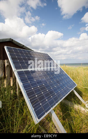 Un panneau solaire génère de l'électricité pour alimenter une clôture électrique qui protège une colonie de Sternes arctiques et peu près de Newton, Bas Norhumberland, UK. Banque D'Images