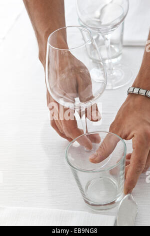 Close up of Waiter's mains Organisation de verres sur table de restaurant