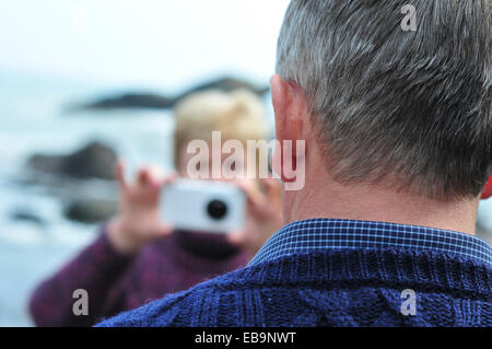Woman Taking Photo of Man with Smart Phone
