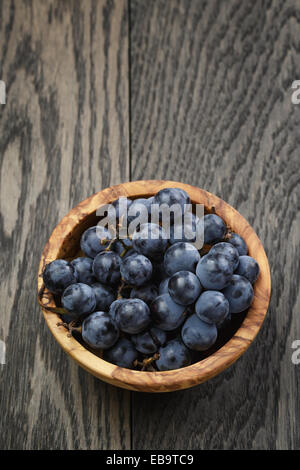 Les raisins mûrs isabella dans bol en bois sur la table, photo simple et rustique Banque D'Images