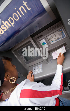 Teenage girl un retrait d'argent à un guichet automatique, Banque D'Images