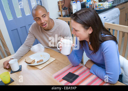 Couple assis à la table de dîner de manger un casse-croûte, Banque D'Images