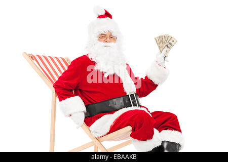 Santa avec de l'argent assis dans un transat président isolé sur fond blanc Banque D'Images