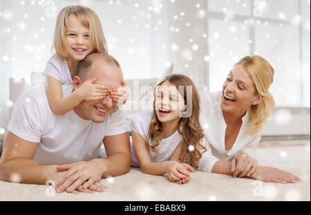 Smiling parents et deux petites filles à la maison Banque D'Images