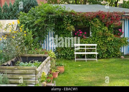 Maison de jardin avec banc et soulevées bed Banque D'Images