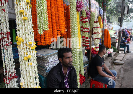 Novembre 2014. Vendeuse de fleurs à son échoppe dans le marché aux fleurs à Dhaka Bangladesh Banque D'Images