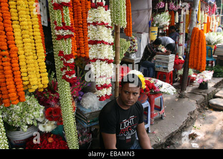 Novembre 2014. Vendeuse de fleurs à son échoppe dans le marché aux fleurs à Dhaka Bangladesh Banque D'Images