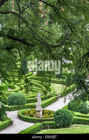 Dans les jardins Renaissance formels du Giardino Giusti, Vérone, Italie. Une vue verdoyante sur les arbres, les haies coupées en boîte et les statues Banque D'Images