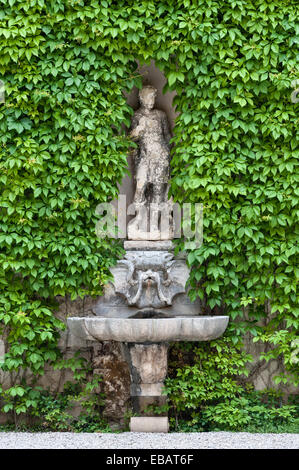 Les jardins Renaissance du Giardino Giusti, Vérone. Une fontaine et une statue d'Apollon dans la cour, avec un mur recouvert de Virginia Creeper Banque D'Images