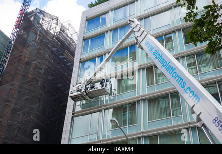 Grue utilisée pour le nettoyage des vitres d'un immeuble moderne en verre dans la ville de New York Banque D'Images