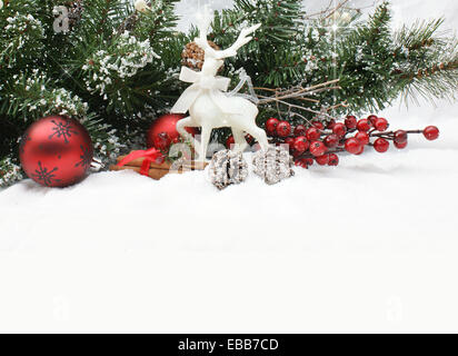Décorations de Noël et arbre branche niché dans la neige Banque D'Images
