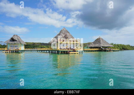 Tropical resort au fil de l'eau bungalow au toit de chaume, mer des Caraïbes Banque D'Images