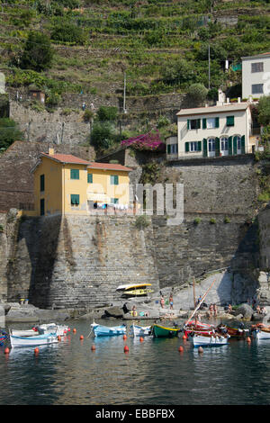 Maisons au bord de l'eau et des bateaux amarrés, petit port de Vernazza Cinque Terre Ligurie Italie Banque D'Images