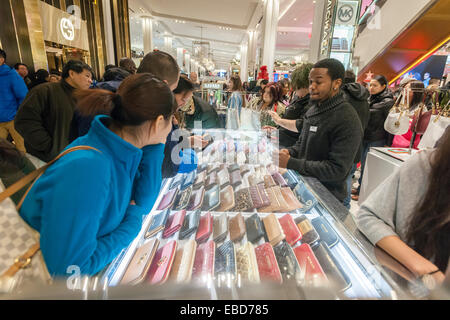 New York, USA. 28 novembre, 2014. Shoppers parcourir Michael Kors cuir dans le Macy's Herald Square flagship store à New York à la recherche d'aubaines sur le lendemain de Thanksgiving, le Black Friday, November 28, 2014. De nombreux détaillants, dont Macy's, ont ouvert leurs portes le soir de l'action de l'extension de la journée de shopping et de l'action de donner le surnom de 'Jeudi gris'. Crédit : Richard Levine/Alamy Live News Banque D'Images