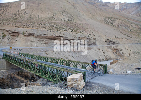 Cycliste de traverser un pont sur la route de Manali à Leh à travers l'himalaya Banque D'Images