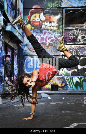 Une grande danseuse et le retournement des coups dans une rue latérale couverte de graffiti dans la région de Melbourne, Victoria, Australie Banque D'Images