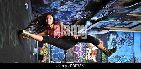 Une grande danseuse et le retournement des coups dans une rue latérale couverte de graffiti dans la région de Melbourne, Victoria, Australie Banque D'Images