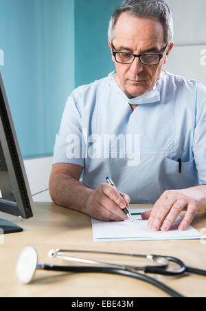 Médecin avec masque Sugical doing Paperwork Banque D'Images