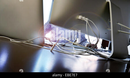 Close-up of man working at desk avec ordinateurs et de fils assortis, Canada Banque D'Images