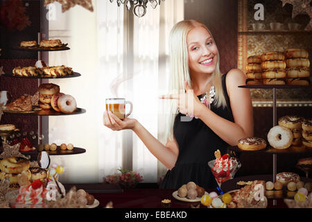 Boulangerie. Heureux vendeuse avec tasse de café en Bakeshop Banque D'Images