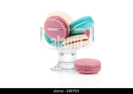 Macarons colorés dans un vase de verre isolé sur fond blanc Banque D'Images