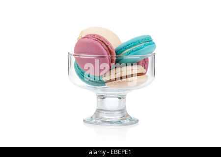 Macarons colorés dans un vase de verre isolé sur fond blanc Banque D'Images