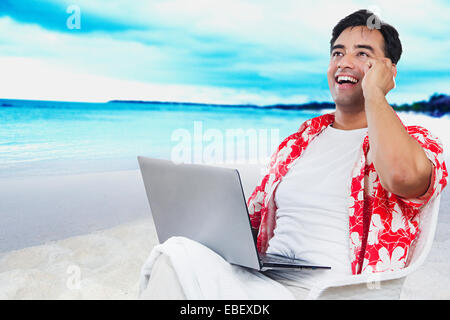 L'homme indien beach Multi Tasking Banque D'Images