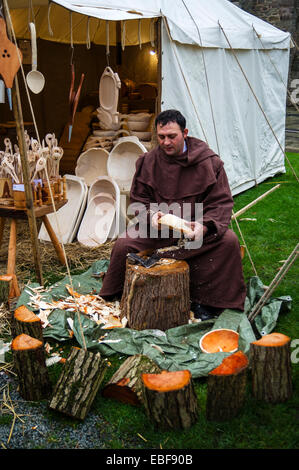 Un homme en costume médiéval faisant un bol en bois à la main à l'Ludlow Castle Noël Nourriture et foire artisanale. Le Shropshire Banque D'Images